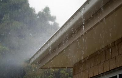 Image of gutters on a home in the rain 