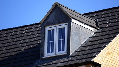 Roof of a home with a clear sky in the background