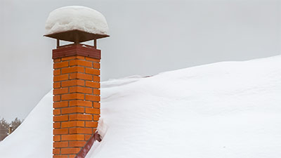 Snow fallen on brick chimney